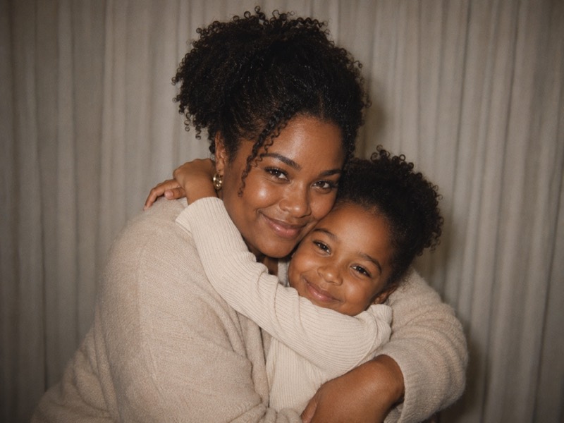 An adult holding their younger self.